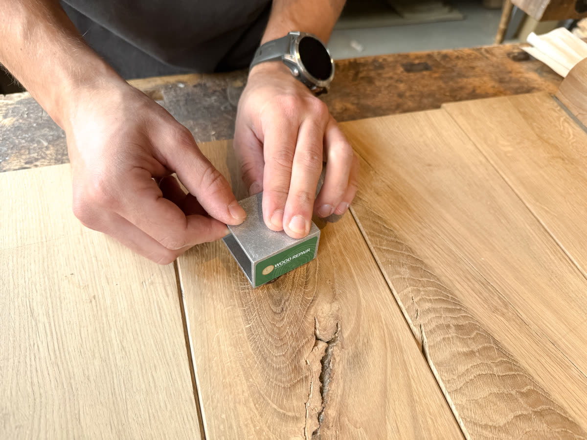 Cooling brick pressed onto a fresh Wood Repair fill, setting it hard in seconds