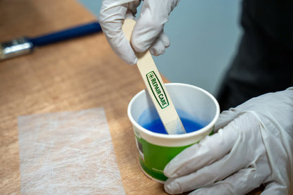 Two-component filler being mixed with an EASY Q wooden spatula in a cup